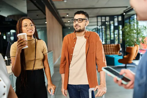 stock image Multicultural colleagues in casual attire, bonding and conversing in a hotel lobby during a corporate trip.