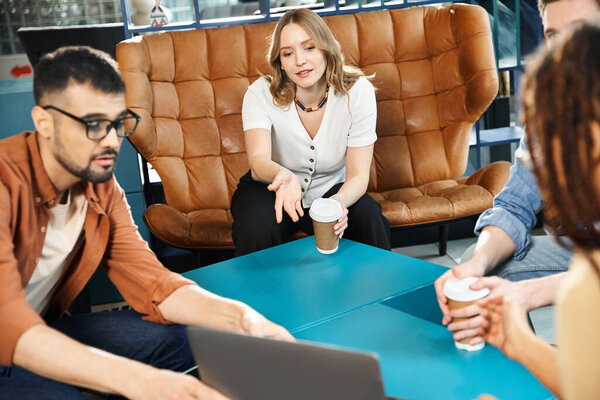 Multicultural colleagues brainstorming around a laptop in a hotel lobby during a corporate trip.