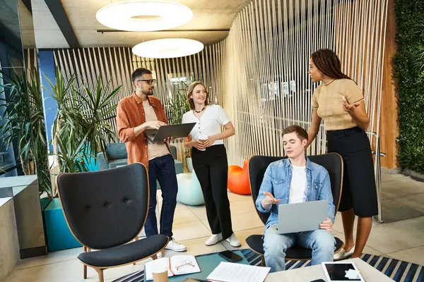 Group Colleagues Modern Coworking Space Huddled Table Laptops Collaborating Startup — Stock Photo, Image
