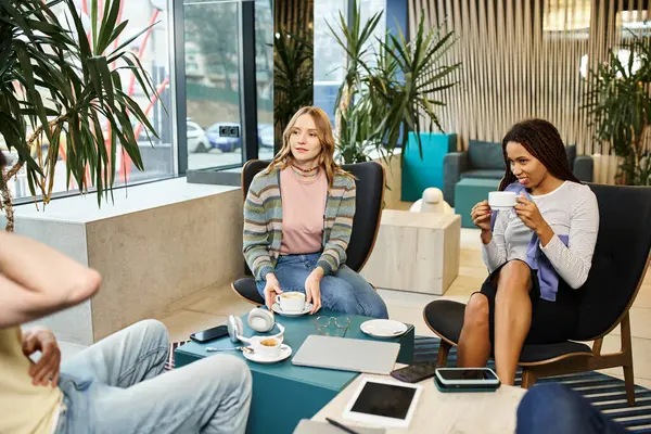 現代のコワーキングスペースでスタイリッシュなコーヒーテーブルの周りに座っている間 コラボレーションとブレインストーミングのアイデアのグループ — ストック写真
