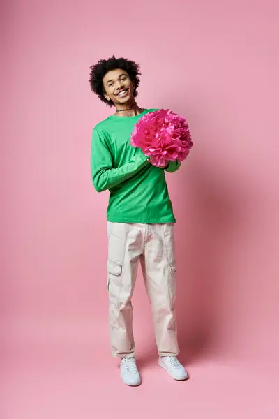 Cheerful Young African American Man Green Shirt Holding Delicate Pink — стоковое фото