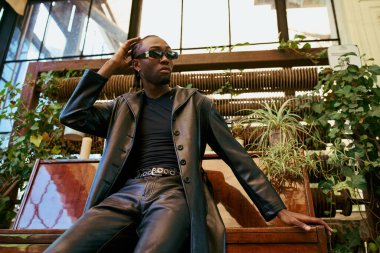 Yakışıklı Afro-Amerikan erkek şık giyimli canlı piyano üzerinde oturuyor..