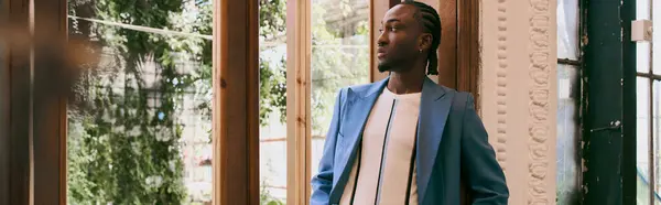 stock image Handsome african american man in sophisticated dapper style standing in front of window