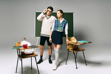 Seçkin erkek ve kadın üniversite ortamında yeşil kurul önünde poz veriyor..