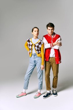 Young male and female students in casual attire strike a pose in a college classroom. clipart