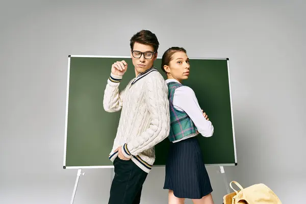 stock image Elegant couple standing in front of green board at college.