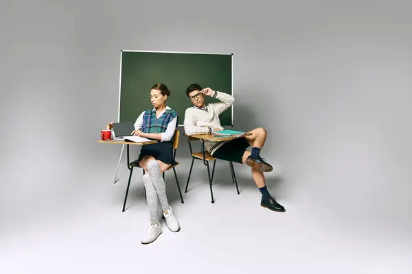 stock image Elegant male and female students sitting in front of a green board in a college setting.