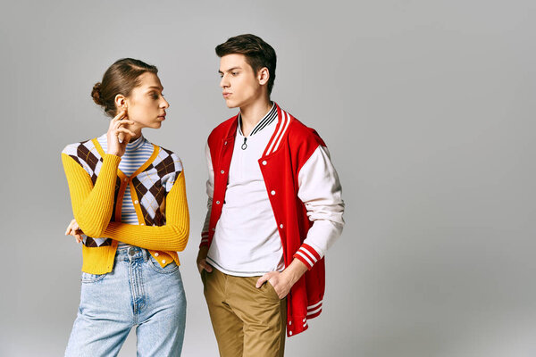 Young male and female students pose coyly in a college classroom.