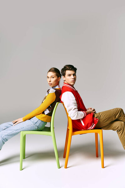 Stylish students lounge on a colorful chair in a college classroom.