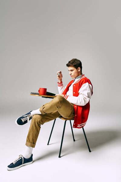 A man in a red jacket sits on a chair.