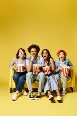 Çok kültürlü, şık giyinmiş arkadaşlar, parlak sarı bir kanepede oturup film izlerler.