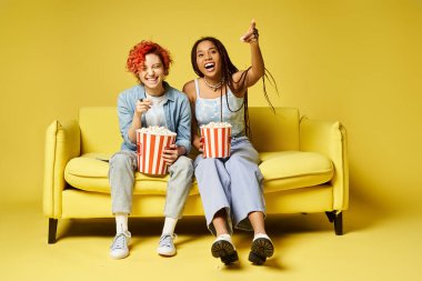 diverse friends sitting atop a yellow couch and watching movie in a stylish setting. clipart