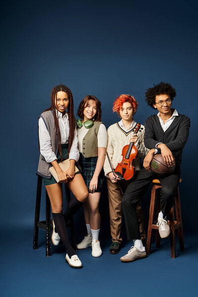 Разнообразная группа молодых друзей, стоят вместе в стильной одежде на темно-синем фоне.