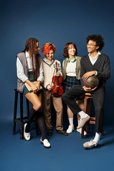 Группа молодых мультикультурных друзей, позируют для фото в стильной одежде на темно-синем фоне.