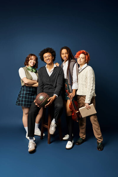 Мультикультурные друзья, стоять вместе в стильной одежде на темно-синем фоне.