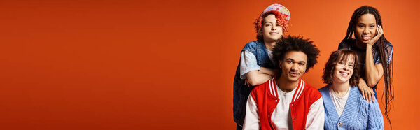 Young interracial friends, including a nonbinary person, standing together in stylish attire in a studio setting.