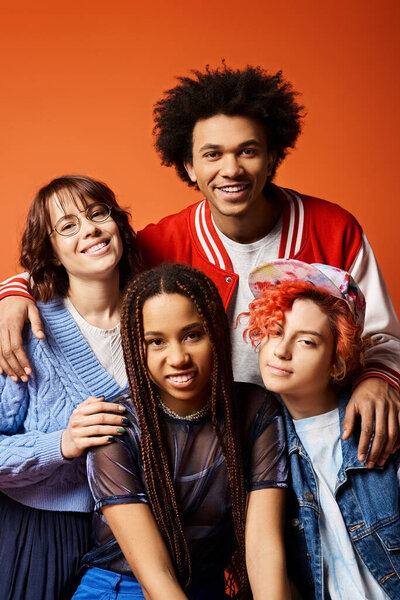 interracial group of young friends, including nonbinary person, posing happily together in stylish studio attire.