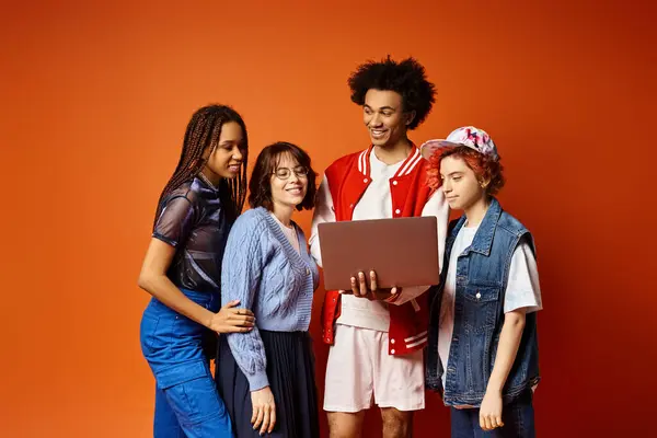 stock image A diverse group of young friends, including a nonbinary person, stand together in stylish attire in a studio setting.