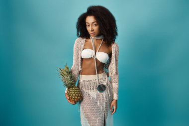 Ananas tutan, bikinili, şık, Afro-Amerikan bir kadın..