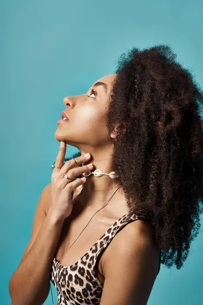 stock image Young African American woman with curly hairdo in stylish swimsuit poses with hand on chin.