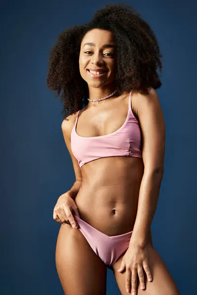 stock image Young African American woman posing confidently in trendy pink bikini.