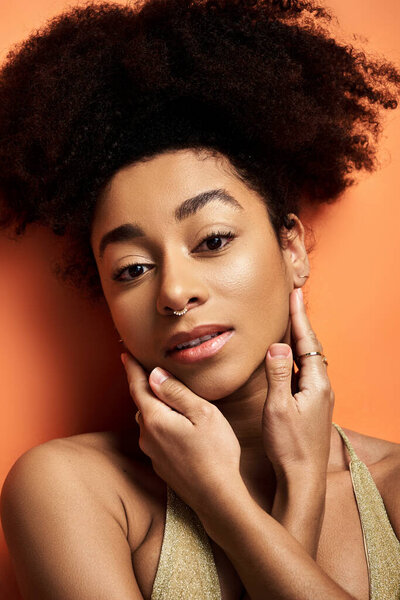 Stylish young African American woman, with curly hairdo, striking a pose.