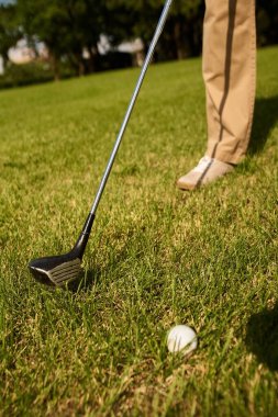 Zarif giyimli bir adam golf kulübündeki yeşil bir sahada golf oynamaya hazırlanıyor. Eski para tarzını ve üst sınıf yaşam tarzını somutlaştırıyor..