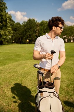 Sakin bir golf sahasında golf çantasıyla şık bir adam, üst sınıf yaşam tarzının zerafetini somutlaştırıyor..