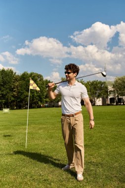 Zarif giyimli bir adam yemyeşil bir alanda golf oynar. Klasik üst sınıf eğlence tarzını somutlaştırır..