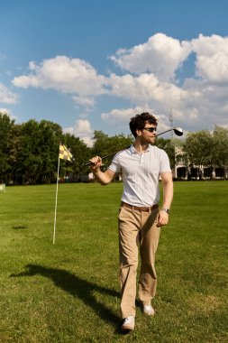Elinde golf sopası var.