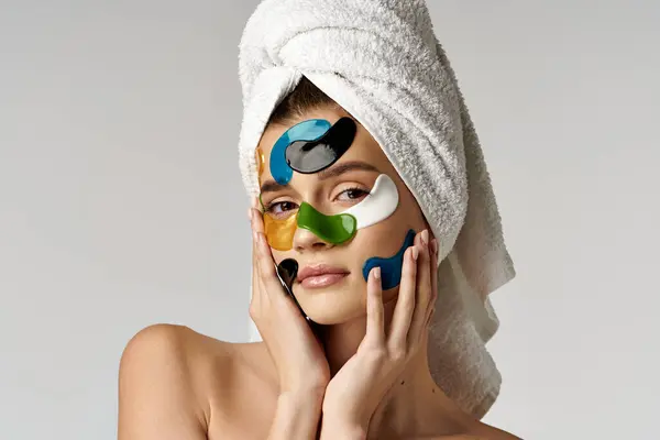 stock image A serene young woman embracing self-care with a towel wrapped around her head, showcasing a beauty routine.