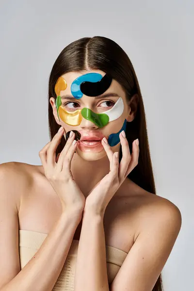 stock image A beautiful young woman with eye patches on her face and hands, showcasing artistic expression and beauty.