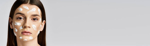 Красивая молодая женщина с очаровательной аурой, ее лицо украшено обилием крема или макияжа.