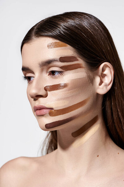 Красивая молодая женщина, украшенная слоями фундамента, демонстрирующая сложный макияж.
