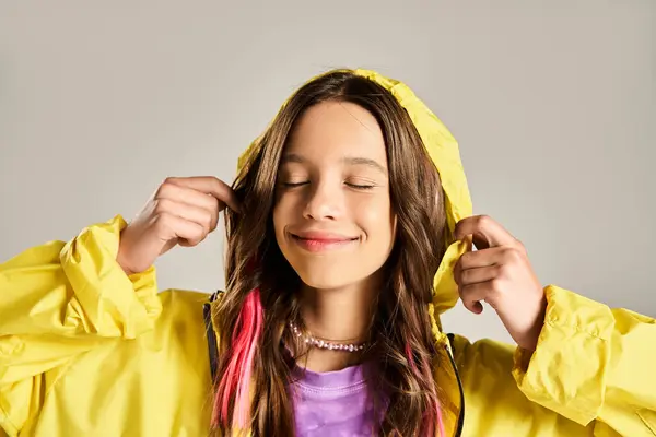 活気に満ちた黄色い雨のコートのスタイリッシュな十代の少女はエネルギー的にポーズします — ストック写真