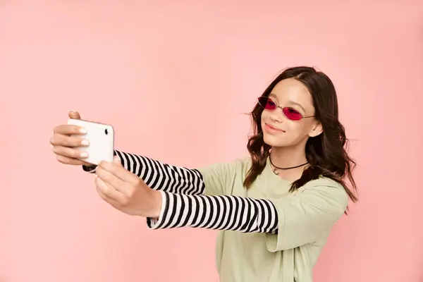 一个穿着华丽衣服 戴着太阳镜 拿着手机自拍的时髦少女 — 图库照片