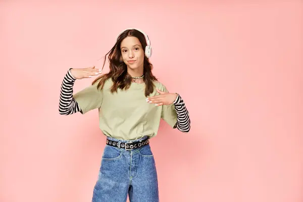 stock image A good looking teenage girl poses actively in stylish vibrant attire of a green shirt and blue jeans.