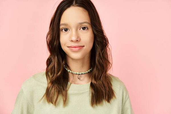 Молодая женщина с длинными волосами позирует в стильной зеленой рубашке, источая яркую и загадочную ауру.