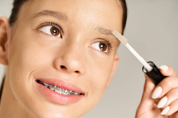 A elegant teenage girl energetically taking care of her eyebrows.