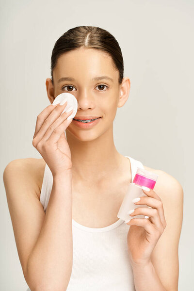 Симпатичная девушка-подросток в яркой одежде с ватным тампоном и ватной палочкой..