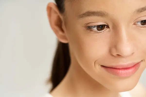 Stock image A teenage girl in vibrant attire smiles warmly, radiating happiness and joy.