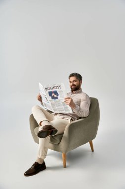 Sakallı zarif bir adam bir sandalyeye oturmuş, gazete okumaya dalmış..