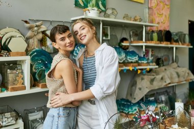İki genç kadın bir dükkanda sevgi dolu bir sarılmayı paylaşıyor..