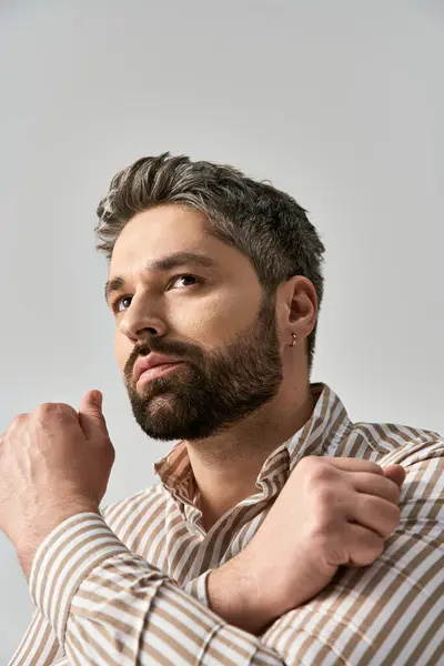 Stylish Man Beard Poses Confidently Striped Shirt Grey Background — Foto Stock