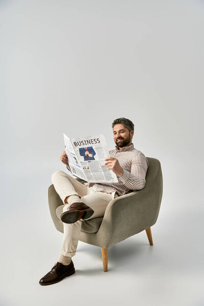 An elegant man with a beard sits in a chair, engrossed in reading a newspaper.