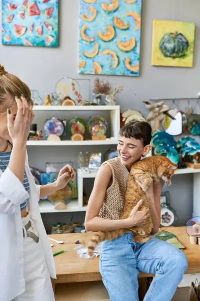 stock image A woman peacefully cradles a cat in a room with her girlfriend.