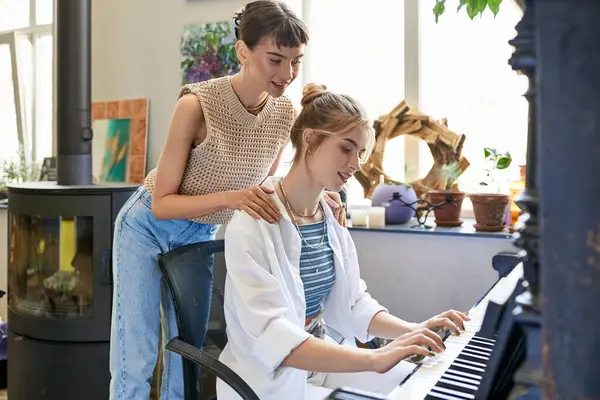 stock image Woman at piano with her girlfriend in art studio.