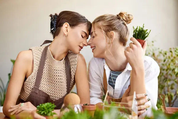 stock image A tender moment between two women in an art studio.