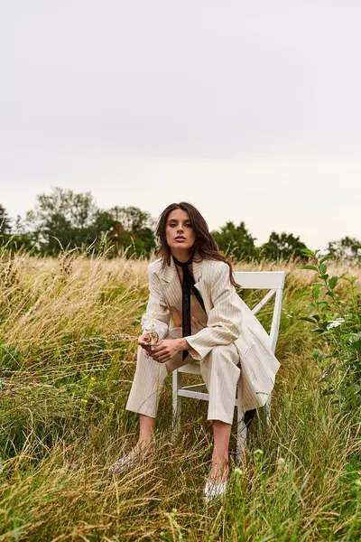 Beautiful Young Woman White Attire Sits Chair Peaceful Field Soaking — Stock Photo, Image