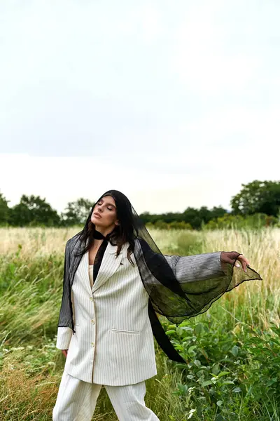 一位身穿白衣的年轻漂亮女子优雅地站在一片高高的草地上 享受夏日的微风 — 图库照片
